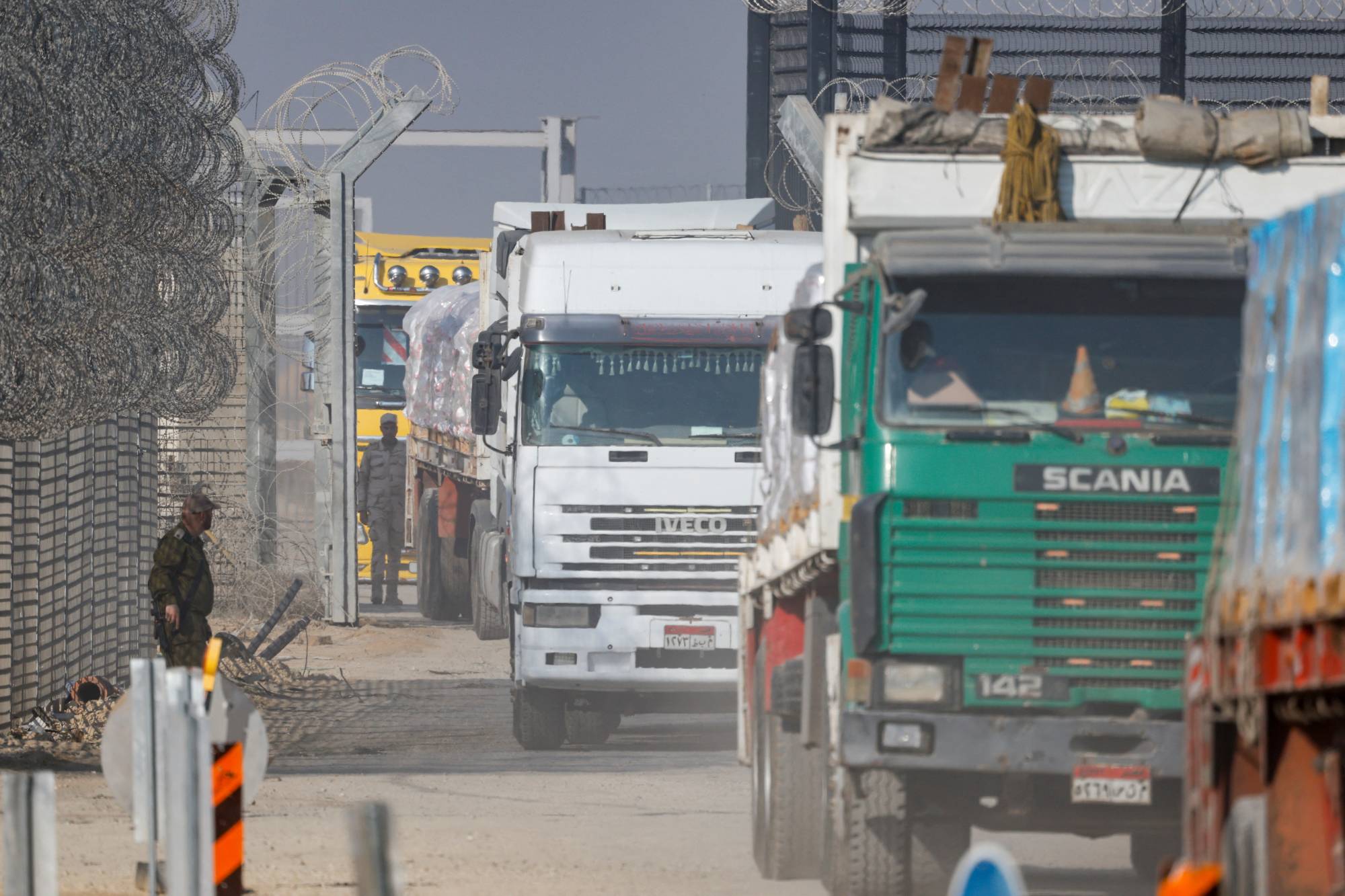 Trucks carry humanitarian aid destined for the Gaza Strip at the Kerem Shalom crossing